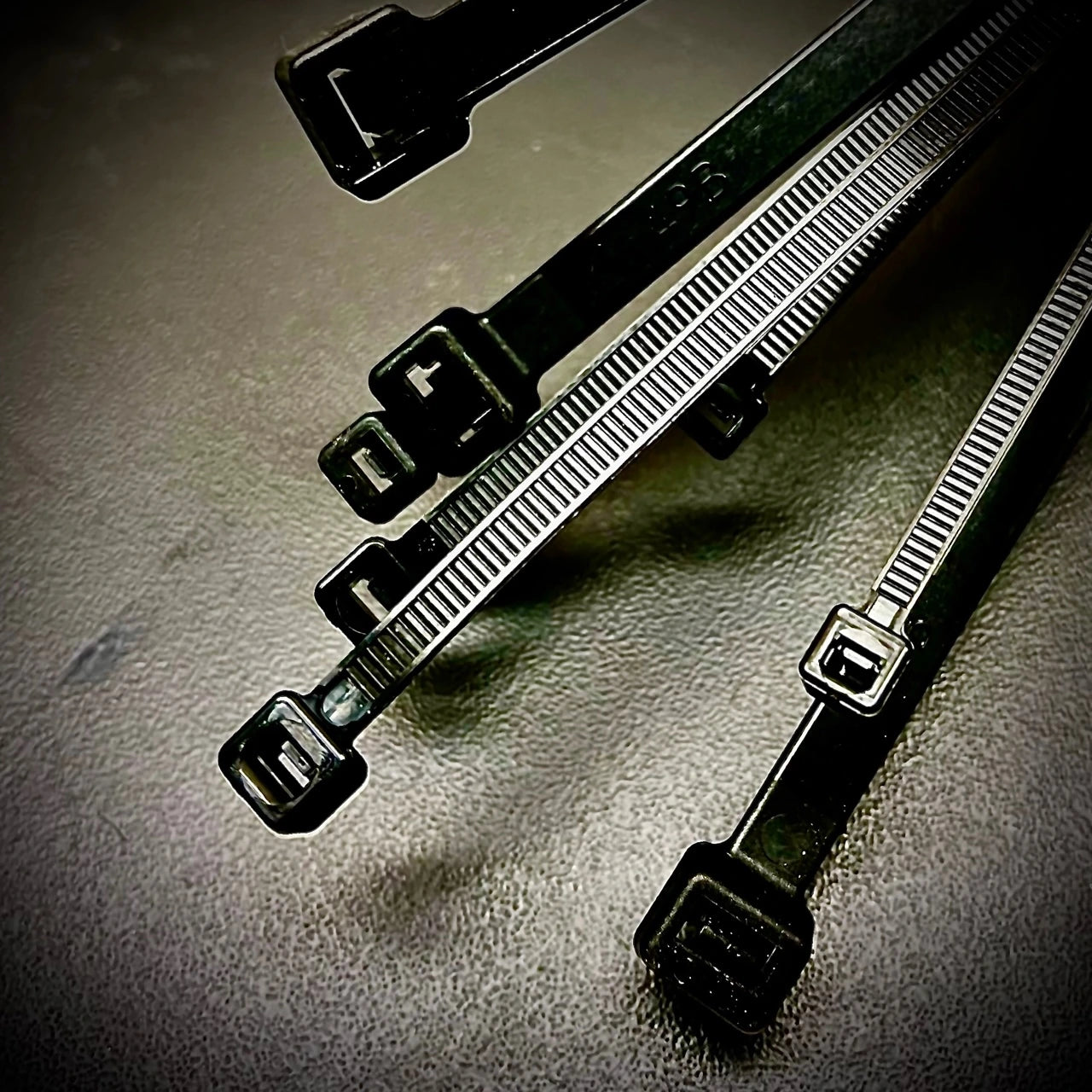 Set of black cable ties on a gray surface