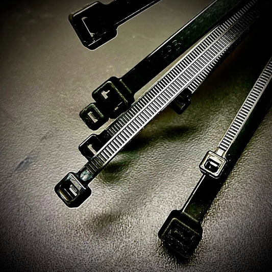Set of black cable ties on a gray surface